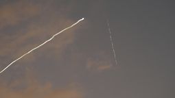 Una estela de humo del sistema de defensa aérea israelí Cúpula de Hierro atraviesa el cielo para interceptar misiles lanzados desde Irán, vista desde Haifa, Israel, la madrugada del martes 24 de junio de 2025. (AP Foto/Baz Ratner)