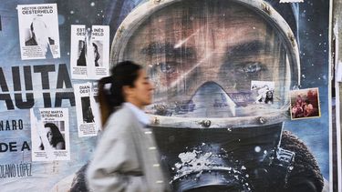 Un anuncio publicitario de la serie de Netflix El Eternauta cubierto parcialmente por carteles del autor del cómic de ciencia ficción Héctor Oesterheld y sus hijas, quienes fueron víctimas de desaparición forzada durante la dictadura militar argentina (1976-1983), el martes 6 de mayo de 2025, en Buenos Aires. (AP Foto/Rodrigo Abd)