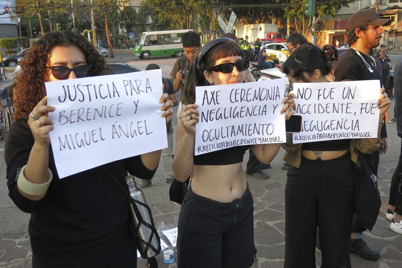 Personas sostienen letreros pidiendo una investigación en una vigilia en la entrada del Parque Bicentenario en la Ciudad de México el domingo 6 de abril de 2025, después de que el festival AXE Ceremonia fuera suspendido por el colapso de una estructura que mató a dos fotógrafos el día antes. (Foto AP/Berenice Bautista)