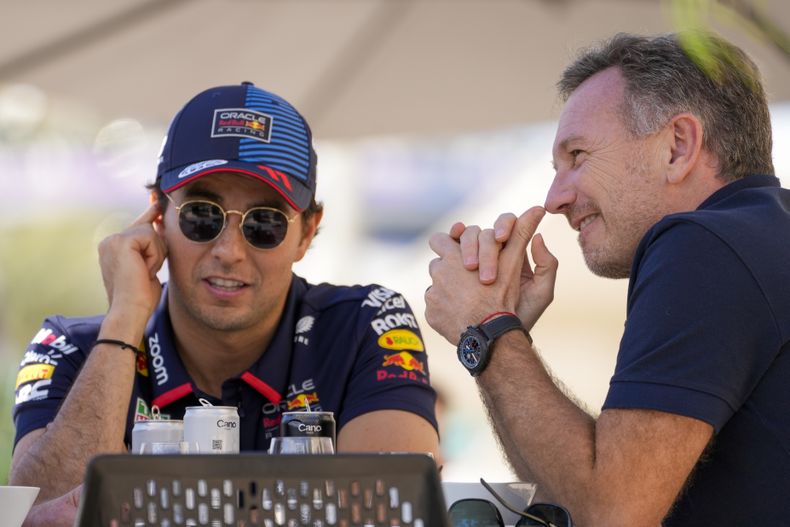 El jefe de Red Bull Christian Horner (derecha) charla con el piloto Sergio Pérez durante las pruebas de pretemporada en el circuito de Sakhir, Bahréin, el miércoles 21 de febrero de 2024. (AP Foto/Darko Bandic)