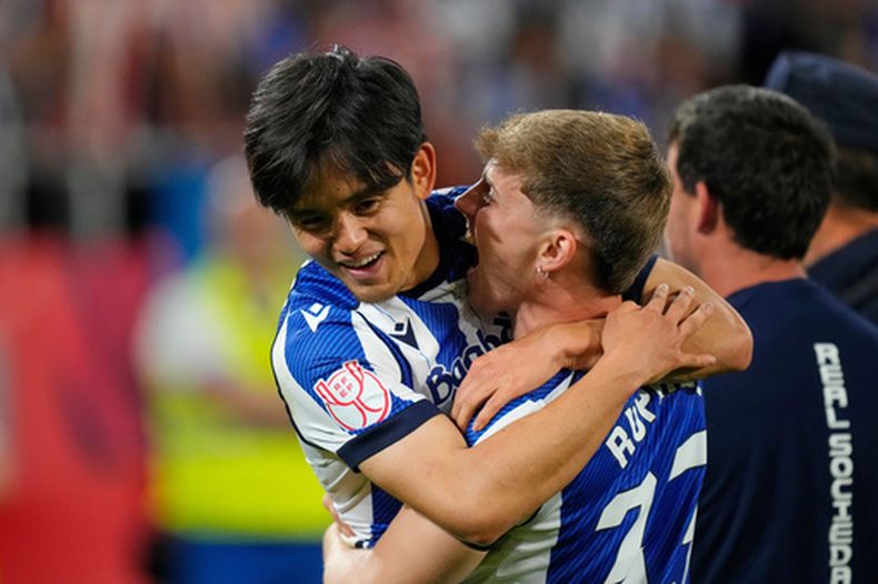 Takefusa Kubo e Inaki Ruperez de la Real Sociedad celebran tras ganar la final de la Copa del Rey al superar en penales al Atlético de Madrid el sábado 18 de abril del 2026. (AP Foto/Jose Breton)