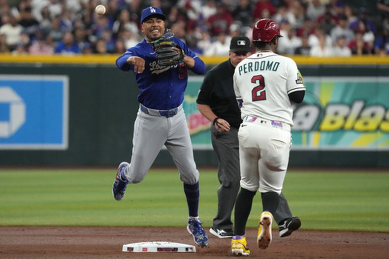 Mookie Betts, de los Dodgers de Los Ángeles, retira a Geraldo Perdomo, de los Diamondbacks de Arizona, con un batazo de Gabriel Moreno en la primera entrada del juego de béisbol de Grandes Ligas del domingo 9 de agosto de 2026, en Phoenix. (AP Foto/Rick Scuteri)
