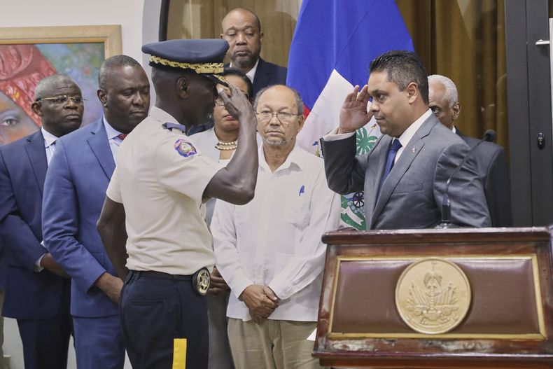 El recién nombrado jefe de la policía haitiana, Vladimir Paraison, izquierda, saluda al presidente del Consejo de Transición, Laurent Saint-Cyr, en su ceremonia de presentación como nuevo jefe interino de la policía, en Puerto Príncipe, Haití, el viernes 8 de agosto de 2025. (AP Foto/Odelyn Joseph)