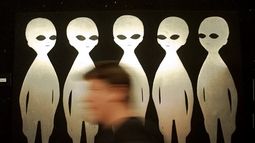 Una persona camina frente a una pintura en el Museo Internacional y Centro de Investigación Ovni, el 10 de junio de 1997, en Roswell, Nuevo México. (AP Foto/Eric Draper, Archivo)