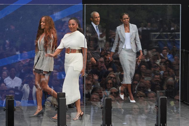 El expresidente Barack Obama, en el centro de la parte trasera, y la ex primera dama Michelle Obama, a la derecha, llegan al escenario con sus hijas, Sasha y Malia Obama, durante la ceremonia de inauguración del Centro Presidencial Obama, el jueves 18 de junio de 2026, en Chicago. (Foto AP/Jeff Roberson)