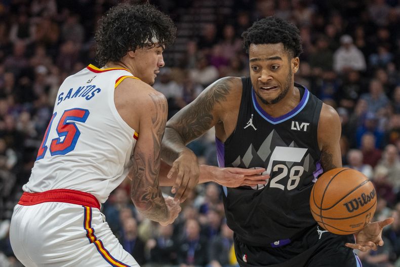 Brice Sensabaugh, alero del Jazz de Utah, trata de avanzar ante Gui Santos, de los Warriors de Golden State, en el encuentro del miércoles 5 de febrero de 2025 (AP Foto/Rick Egan)