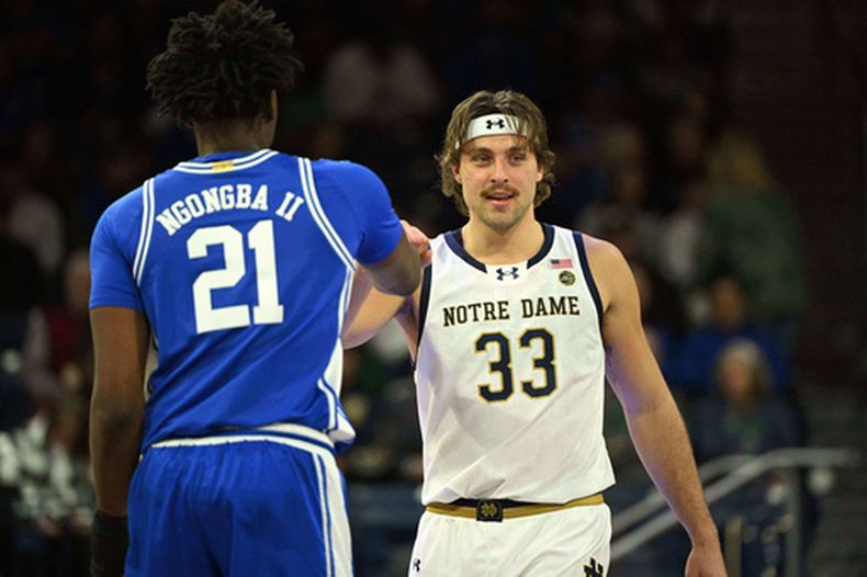 ARCHIVO - Foto del 24 de febrero del 2026, el alero de Notre Dame Carson Towt le da la mano al pívot de Duke Patrick Ngongba antes de un juego de la NCAA. (AP Foto/Marc Lebryk, Archivo)