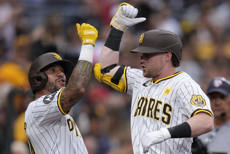 Jake Cronenworth celebra con su compañero venezolano de los Padres de San Diego David Peralta su jonrón de tres carreras en la cuarta entrada ante los Diamondbacks de Arizona el sábado 8 de junio del 2024. (AP Foto/Gregory Bull)