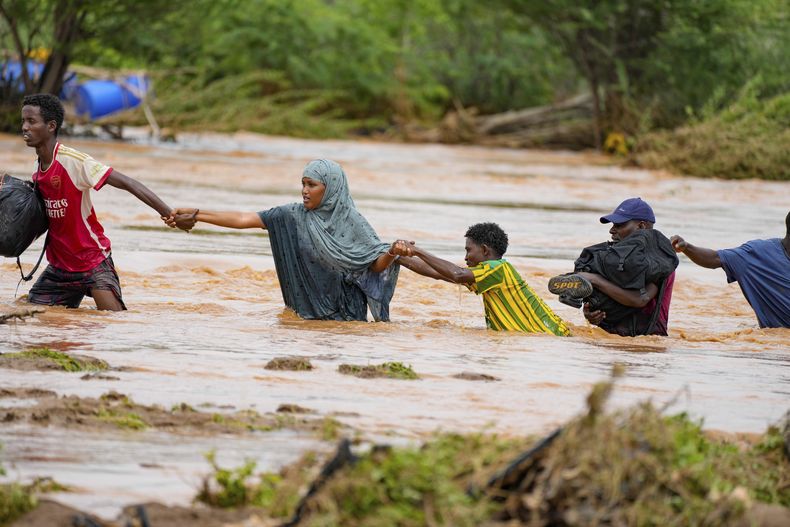 ARCHIVO - Residentes cruzan una carretera dañada por las lluvias de El Niño en Tula, en el condado del río Tana en Kenia, el sábado 25 de noviembre de 2023. Las graves inundaciones en el país han matado a decenas y desplazado a miles, según estimaciones de la Oficina de Coordinación de Asuntos Humanitarios de las Naciones Unidas. (Foto AP/Brian Inganga, archivo)
