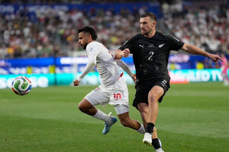 Tim Payne (2), de Nueva Zelanda, disputa el balón con Mehdi Ghayedi, de Irán, en un partido del Grupo G del Mundial en Inglewood, California, lunes 15 de junio, 2026. (AP Foto/Andre Penner)