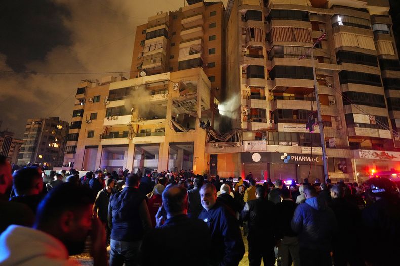 Varias personas se reúnen afuera de un edifico dañado luego de una explosión en el suburbio de Dahiyeh, en el sur de Beirut, Líbano, el martes 2 de enero de 2024. (AP Foto/Bilal Hussein)