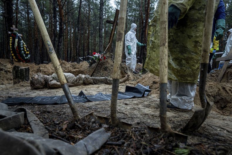 El cuerpo de un civil yace en el piso durante una exhumación en la recientemente capturada zona de Izium, Ucrania, el viernes 23 de septiembre de 2022. (AP Foto/Evgeniy Maloletka)