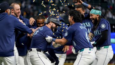 Mitch Haniger, centro, de los Marineros de Seattle, es rociado con chicles por parte de sus compañeros después de impulsar la carrera de la victoria contra los Medias Blancas de Chicago durante la décima entrada el miércoles 12 de junio de 2024, en Seattle. (AP Foto/Lindsey Wasson)