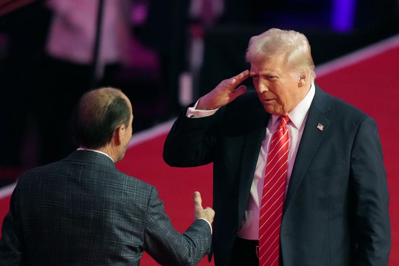 El presidente electo Donald Trump saluda a Lee Greenwood en un mitin previo a la 60ª toma de posesión presidencial, el domingo 19 de enero de 2025, en Washington. (Foto AP/Alex Brandon)
