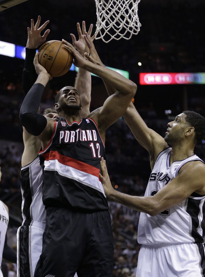 LaMarcus Aldridge (12), de los Trail Blazers de Portland, busca el aro entre la marca de Tim Duncan, de los Spurs de San Antonio, a la derecha, y el brasile&ntilde;o Tiago Splitter en la segunda mitad del segundo partido de la serie de semifinales entre a