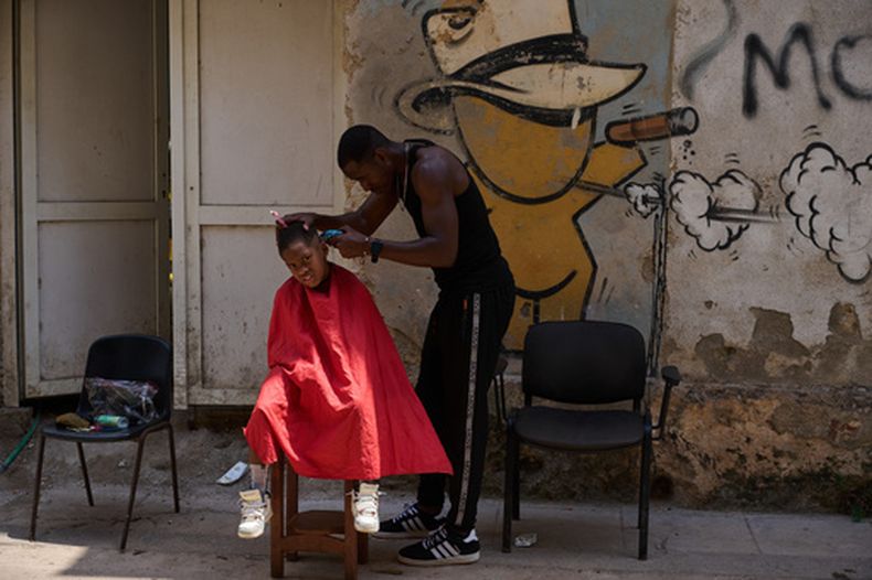 Un barbero corta el pelo a un niño en una calle de La Habana, el 22 de abril de 2026. (Foto AP/Ramón Espinosa)