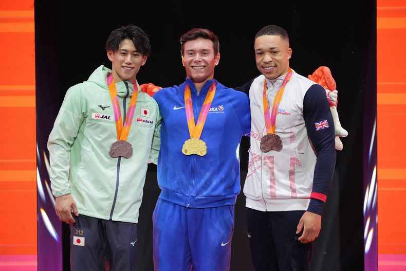 El medallista de oro Brody Malone de Estados Unidos, al centro, junto al medallista de plata Daiki Hashimoto de Japón, a la izquierda, y el medallista de bronce británico Joe Fraser, derecha, tras la prueba de barras horizontales en el Mundial de Gimnasia el sábado 25 de octubre del 2025. (AP Foto/Achmad Ibrahim)