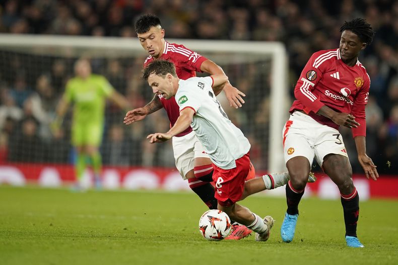 Lisandro Martínez (izquierda) y Kobbie Mainoo (derecha) del Manchester United pugnan el balón con Youri Regeer de FC Twente en el partido de la Liga Europa, el miércoles 25 de septiembre de 2024, en Manchester. (AP Foto/Dave Thompson)
