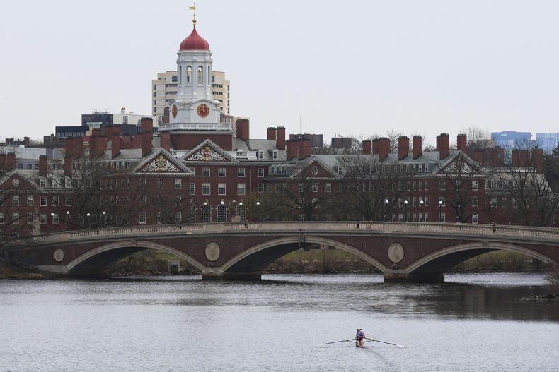 Una persona rema por el río Charles, cerca de la Universidad de Harvard, al fondo, el martes 15 de abril de 2025, en Cambridge, Massachusetts. (AP Foto/Charles Krupa)
