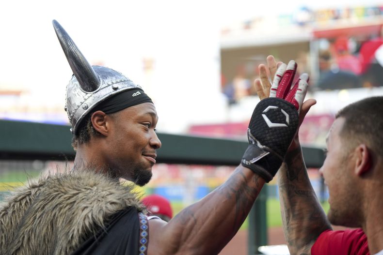 Will Benson, de los Rojos de Cincinnati, es felicitado por Nick Senzel luego de conectar un jonrón de tres carreras ante los Gigantes de San Francisco, el miércoles 19 de julio de 2023 (AP Foto/Aaron Doster)