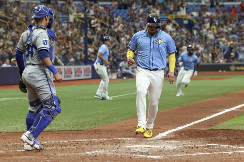 El mexicano de los Rays de Tampa bay, Isaac Paredes, anota frente al receptor venezolano de los Reales de Kansas City, Freddy Fermín (izquierda), durante la séptima entrada del juego de béisbol el domingo 26 de mayo de 2024, en San Petersburgo, Florida. (AP Foto/Mike Carlson)