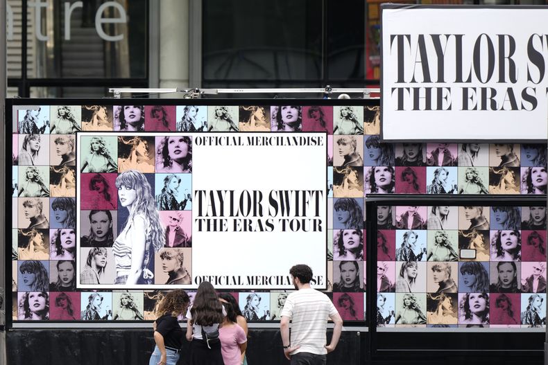 Una familia mira un quiosco de productos de Taylor Swift en el estadio de Wembley en Londres, el miércoles 14 de agosto de 2024, antes de una serie de conciertos de Taylor Swift que comenzarán el jueves. (Foto AP/Alastair Grant)