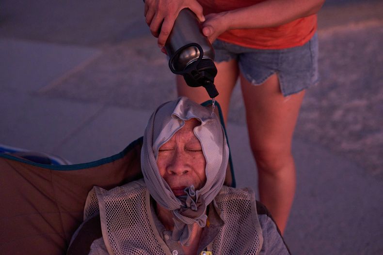ARCHIVO - Grace Chyuwei vierte agua sobre Joe Chyuwei para ayudar con el calor, el 3 de agosto de 2025 en el Parque Nacional Valle de la Muerte en California, Estados Unidos. (AP Foto/John Locher, Archivo)