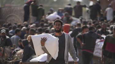 Palestino se reúnen para recibir costales de harina distribuidos por la Agencia de Naciones Unidas para los Refugiados de Palestina en Oriente Próximo (UNRWA), en Deir al Balah, Franja de Gaza, el sábado 2 de noviembre de 2024. (AP Foto/Abdel Kareem Hana)