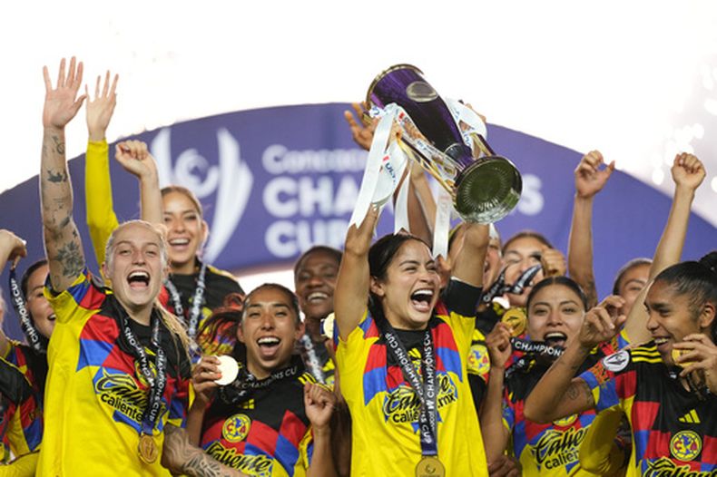 Scarlett Camberos, del América de México, en el centro, levanta el trofeo tras ganar la final de la Copa de Campeones Femenina de la CONCACAF contra el Washington Spirit de Estados Unidos en Pachuca, México, el sábado 23 de mayo de 2026. (Foto AP/Fernando Llano)