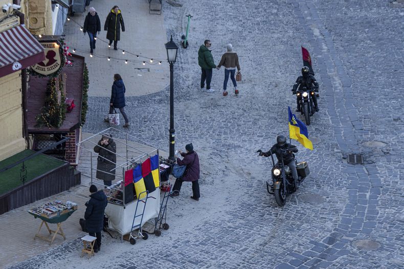 Motociclistas con banderas ucranianas recorren el centro de Kiev, miércoles 20 de diciembre de 2023. (AP Foto/Evgeniy Maloletka)