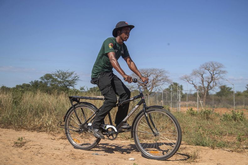 Capon Sibanda, voluntario local entrenado para ser guardián comunitario para encuentros entre personas y elefantes, se desplaza sobre una bicicleta el miércoles 30 de abril de 2025, en Hwange, Zimbabue. (AP Foto/Aaron Ufumeli)