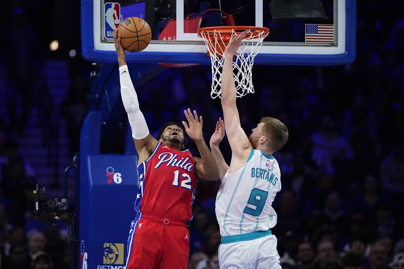 Tobias Harris (12), de los 76ers de Filadelfia, se alza para tomar un tiro frente a Davis Bertans, de los Hornets de Charlotte, durante la segunda mitad del juego de baloncesto de la NBA, el viernes 1 de marzo de 2024, en Filadelfia. (AP Foto/Matt Slocum)