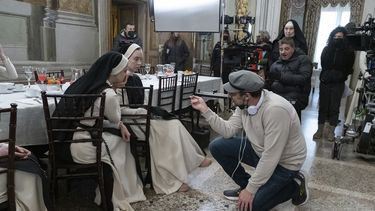 En esta imagen proporcionada por Neon, el director Michael Mohan, de rodillas a la derecha, con la actriz Sydney Sweeney, segunda de izquierda a derecha, en el set de la película Immaculate. (Neon vía AP)