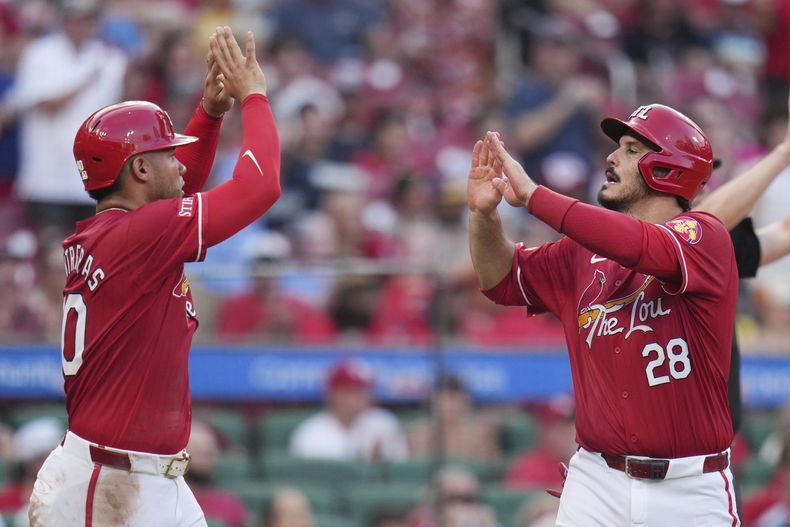 Willson Contreras, izquierda, y Nolan Arenado, de los Cardenales de San Luis, celebran después de anotar durante la cuarta entrada del juego de béisbol frente a los Padres de San Diego el viernes 25 de julio de 2025, en San Luis. (AP Foto/Jeff Roberson)