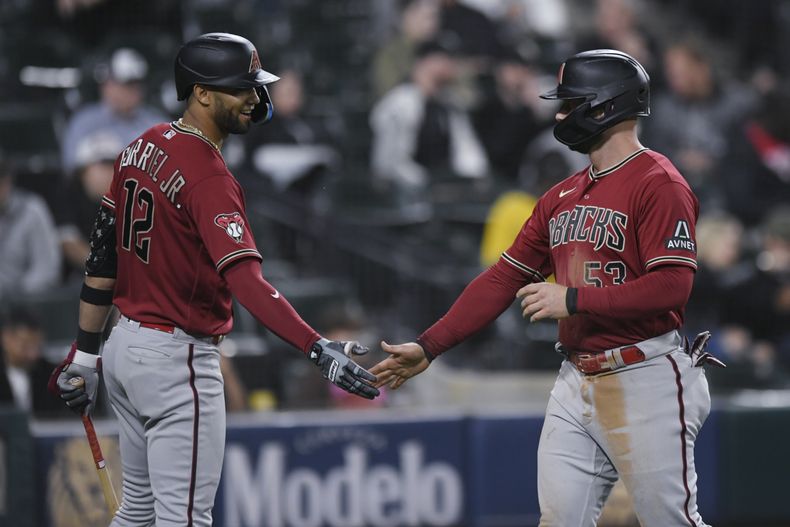 Christian Walker, de los Diamondbacks de Arizona, festeja con el cubano Lourdes Gurriel Jr., luego de anotar ante los Medias Blancas de Chicago, el martes 26 de septiembre de 2023 (AP Foto/Paul Beaty)