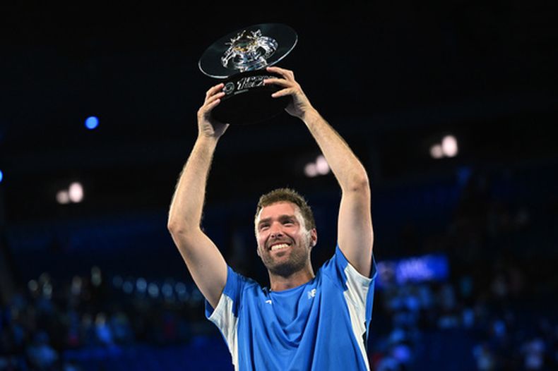 El australiano Jordan Smith alza el trofeo tras vencer a la taiwanesa Joanna Garland en el Slam a Un Punto, el miércoles 14 de enero de 2026, en Melbourne (James Ross/AAP Image via AP)
