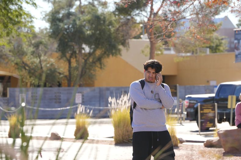 Un estudiante de la Universidad de Nevada campus Las Vegas habla por teléfono luego de que se reportó un tiroteo en el lugar, el miércoles 6 de diciembre de 2023, en Las Vegas. (AP Foto/Lucas Peltier)