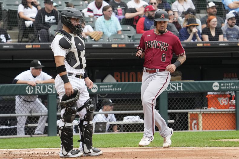 Jace Peterson, derecha, de los Diamondbacks de Arizona, anota con un doble productor de dos carreras de Corbin Carroll ante la mirada del receptor de Medias Blancas de Chicago Carlos Pérez, en la tercera entrada del juego de béisbol en Chicago, el miércoles 27 de septiembre de 2023. (AP Foto/Nam Y. Huh)