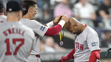 Jarren Duran (izquierda) de los Medias Rojas de Boston cuelga una medalla a su compañero Jamie Westbrook tras el jonrón de Westbrook ante los Medias Blancas de Chicago, el jueves 6 de junio de 202, en Chicago. (AP Photo/Charles Rex Arbogast)