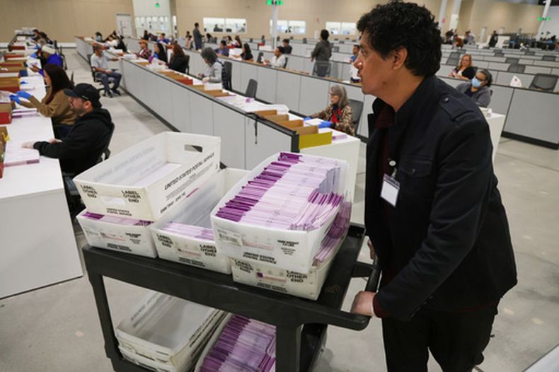 ARCHIVO – Un trabajador empuja un carrito con boletas electorales recibidas en el Centro de Procesamiento de Boletas del condado de Los Ángeles, el 4 de noviembre de 2025, en City of Industry, California. (AP Foto/Ethan Swope, Archivo)