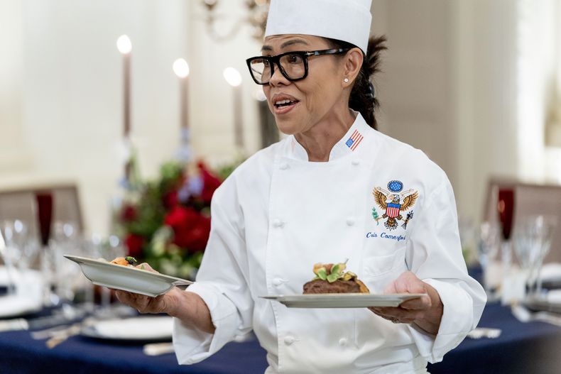 ARCHIVO - La chef ejecutiva de la Casa Blanca, Cris Comerford, sostiene platos mientras habla durante una vista previa a los medios de la cena de Estado con el presidente Joe Biden y el presidente francés Emmanuel Macron en el Comedor de Estado de la Casa Blanca, en Washington, el 30 de noviembre de 2022. (AP Foto/Andrew Harnik, Archivo)