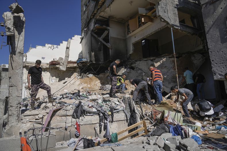 Civiles palestinos inspeccionan los escombros de un edificio tras una operación israelí en el campamento de refugiados Nur Shams, cerca del poblado cisjordano de Tulkarem, el domingo 30 de junio de 2024. (AP Foto/Majdi Mohammed)