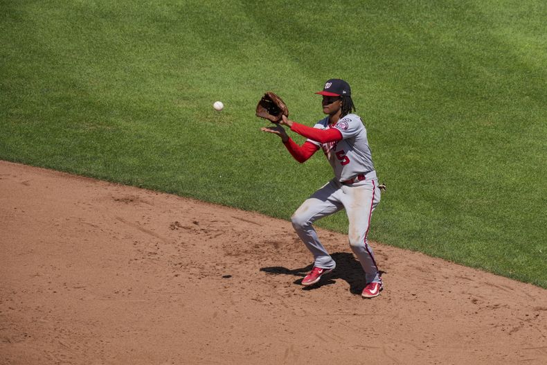 CJ Abrams de los Nacionales de Washington fildea un rodado en el juego ante los Rojos de Cincinnati, el domingo 6 de agosto de 2023, en Cincinnati. (AP Foto/Aaron Doster)