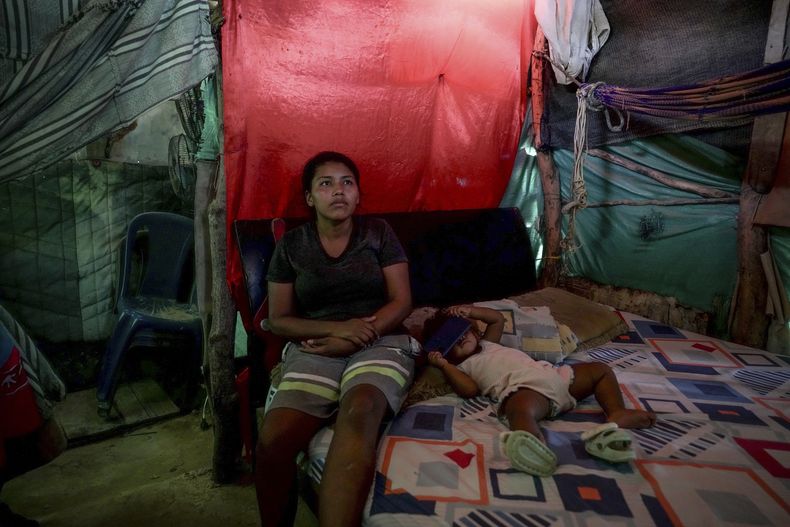 Luciane Mengual, de 22 años, una mujer indígena de la comunidad wayúu, posa con su bebé en su casa en el barrio Villa del Sur, en las afueras de Riohacha, Colombia, el martes 4 de febrero de 2025. (AP foto/Ivan Valencia)