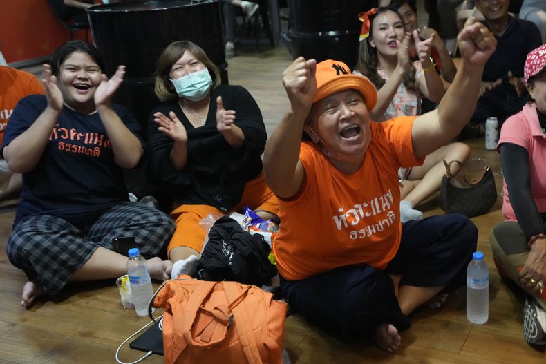 Simpatizantes del Partido Avanzar celebran mientras ven el conteo de votos por televisión en la sede del partido, el domingo 14 de mayo de 2023, en Bangkok. (AP Foto/Sakchai Lalit)