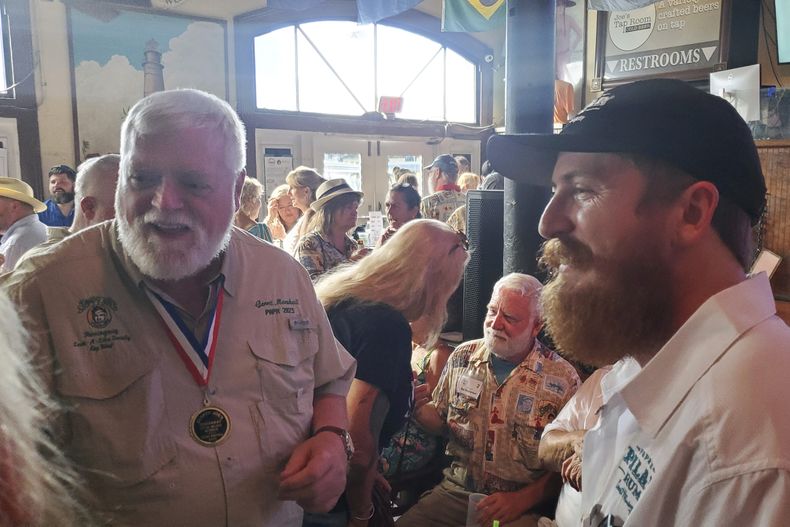 Stephen Hemingway Adams, derecha, bisnieto de Ernest Hemingway, habla con el ganador del Concurso de imitaciones de Hemingway 2023, Gerrit Marshall, en el Sloppy Joes Bar en Key West, Florida, el miércoles 17 de julio de 2024. (Foto AP/David Fischer)