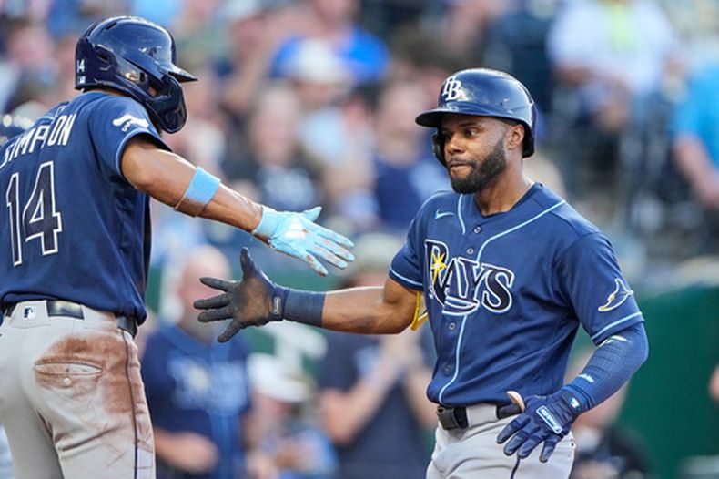 Cedric Mullins (derecha), de los Rays de Tampa Bay, celebra con Chandler Simpson (14) tras conectar un jonrón de dos carreras durante la quinta entrada de un partido de béisbol contra los Reales de Kansas City, el jueves 2 de julio de 2026, en Kansas City, Misuri. (Foto AP/Charlie Riedel)
