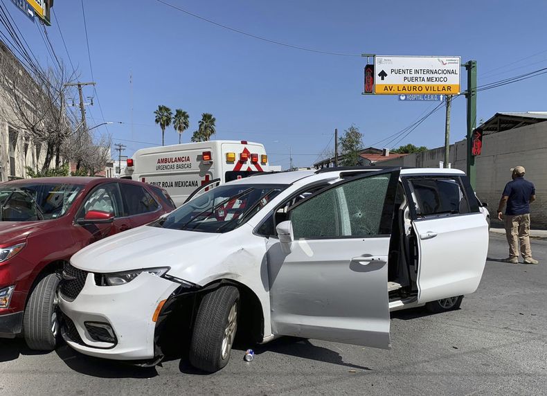 Un miembro de las fuerzas de seguridad mexicanas permanece junto a una minivan blanca con placas de Carolina del Norte y varios agujeros de bala, en el lugar donde el 3 de marzo de 2023 hombres armados secuestraron a cuatro estadounidenses que cruzaron a México desde Texas. (Foto AP, archivo)
