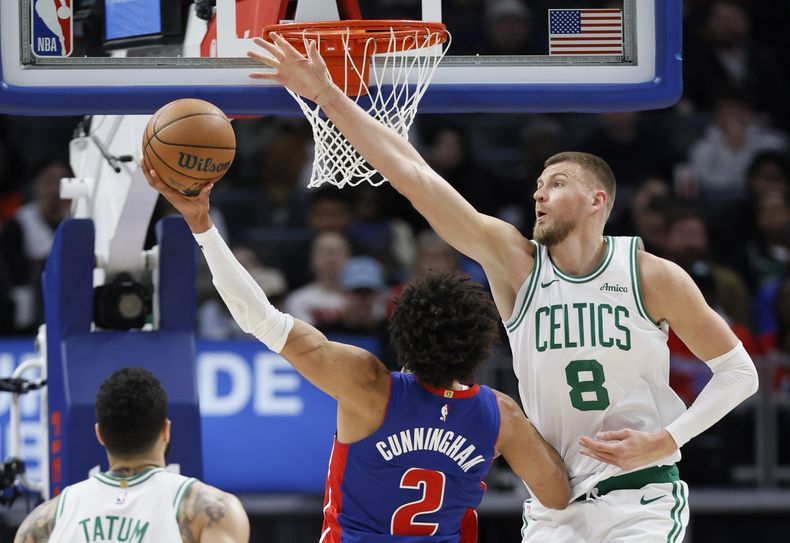 Kris Dunn (8), de los Celtics de Boston, intenta bloquear un tiro de Cade Cunningham (2), de los Pistons de Detroit durante la primera mitad del juego de baloncesto de la NBA, el miércoles 26 de febrero de 2025, en Detroit. (AP Foto/Duane Burleson)