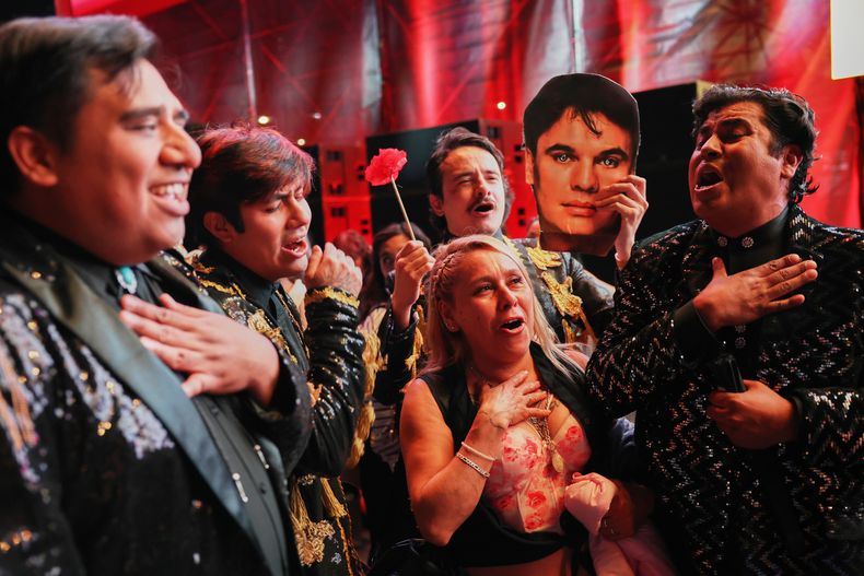 Imitadores de Juan Gabriel cantan en el Zócalo, la principal plaza de la Ciudad de México, sábado 8 de noviembre de 2025, antes de una proyección gratuita del concierto que el fallecido cantante mexicano ofreció en Bellas Artes en 1990. (AP Photo/Claudia Rosel)